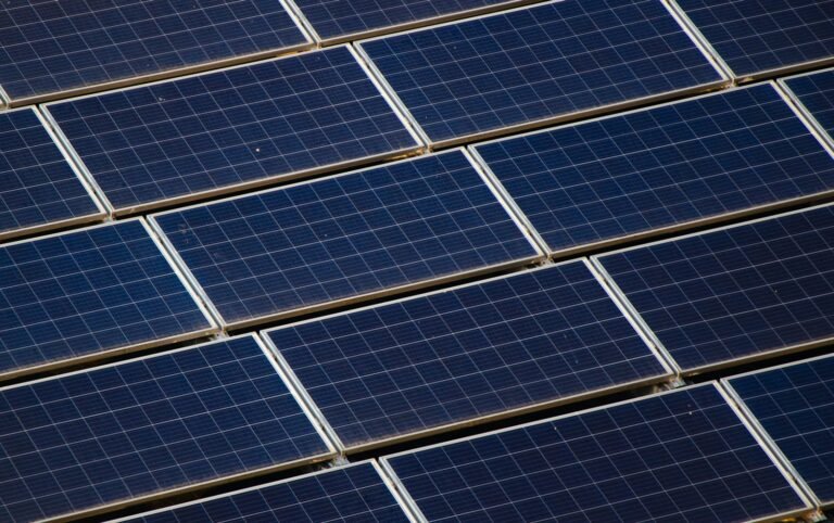 Large-scale solar array covering an industrial warehouse rooftop