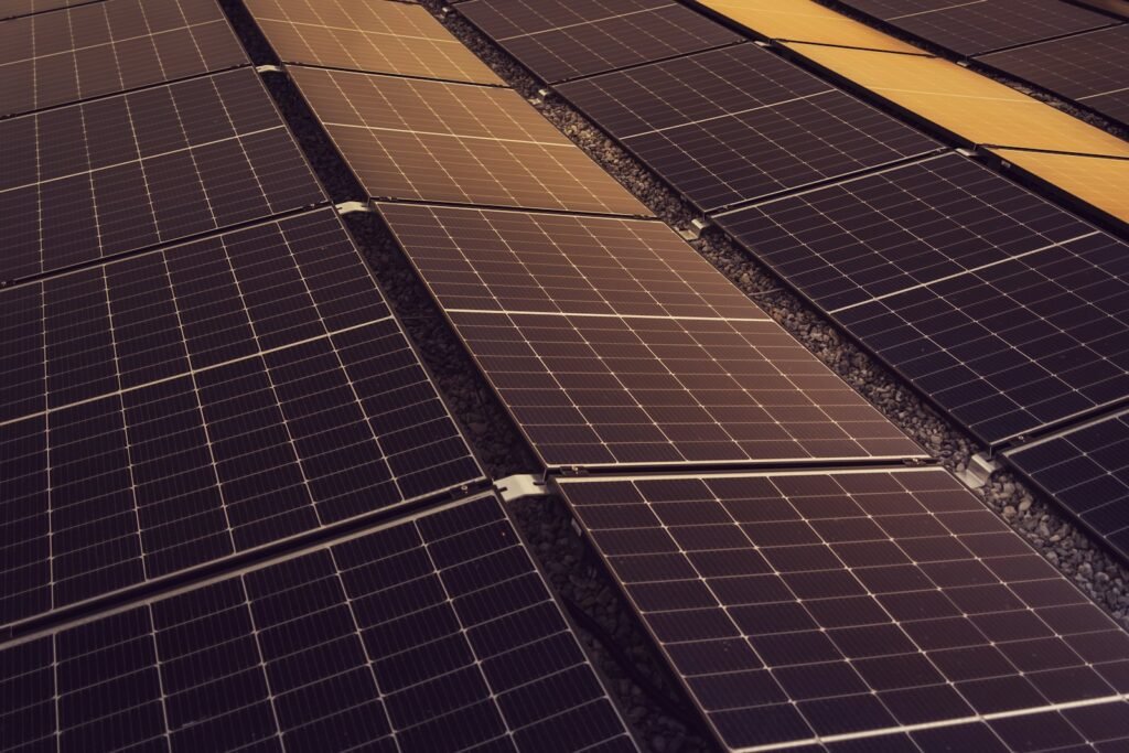 Rows of solar modules covering the roof of a large industrial facility